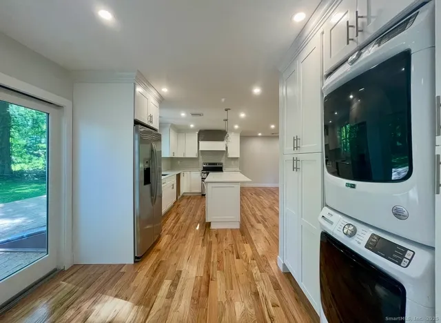 a view of a kitchen with cabinets stainless steel appliances and a window