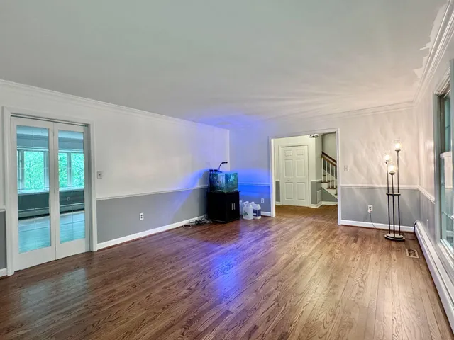 a view of empty room with wooden floor and fireplace