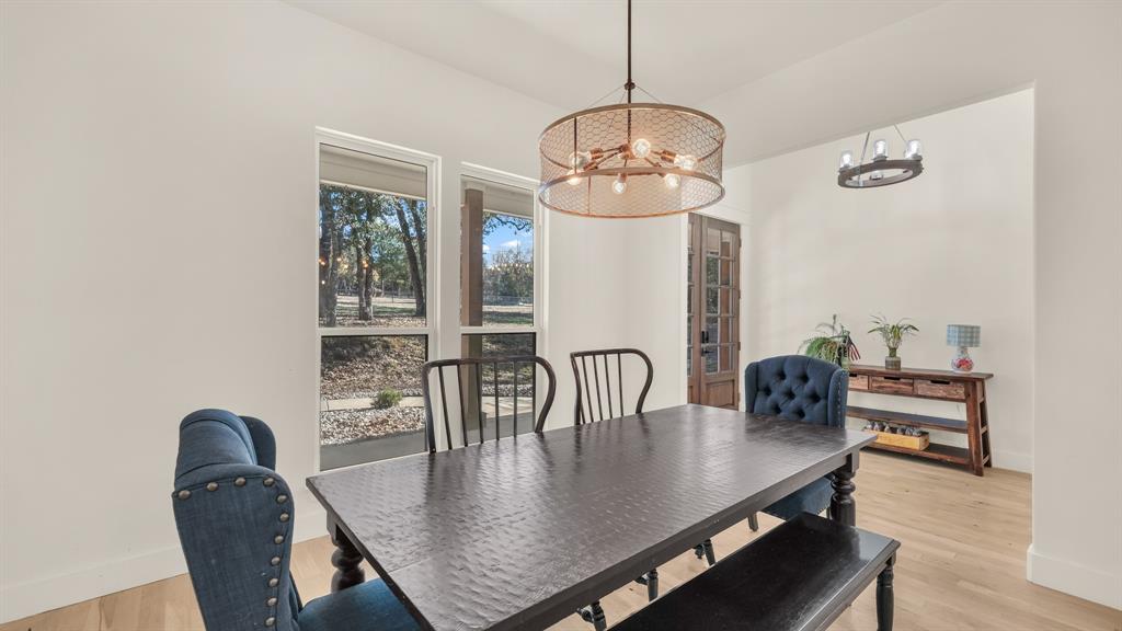 374 Glade Valley Road Azle, TX 76020 - Photo 10 of 38 a view of a dining room with furniture a chandelier and wooden floor