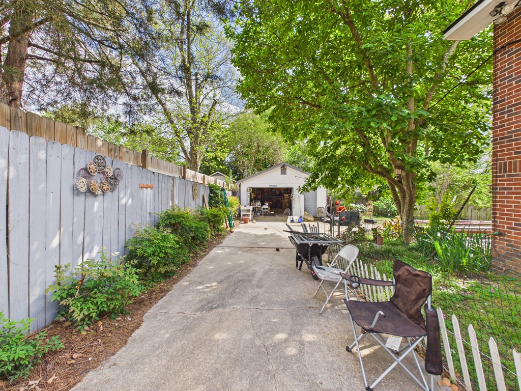 1608 39th Street Columbus, GA 31904 - Photo 52 of 63 a view of a patio with table and chairs potted plants and large tree