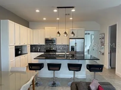 a kitchen with stainless steel appliances kitchen island granite countertop a table and chairs in it