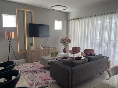 166 Captiva Drive Davenport, FL 33896 - Photo 3 of 8 a living room with furniture and a flat screen tv