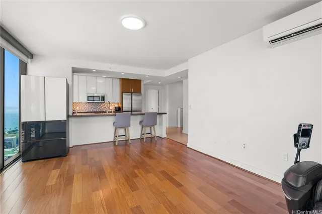 a living room with stainless steel appliances kitchen island granite countertop furniture and wooden floor
