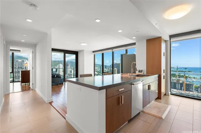a large kitchen with kitchen island a large window a sink and cabinets