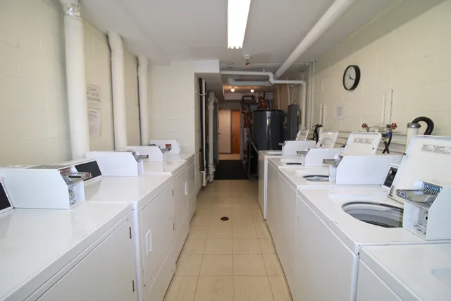 a large white room with a sink and washer