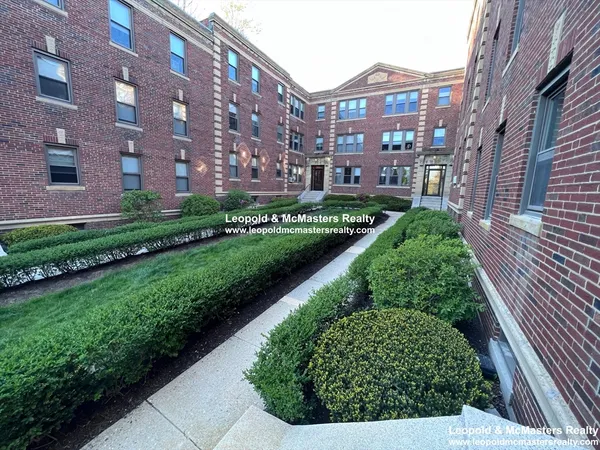 a view of a brick building next to a big yard
