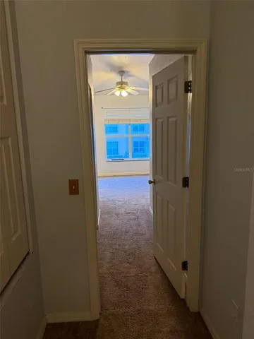 a view of a hallway with wooden floor and a door