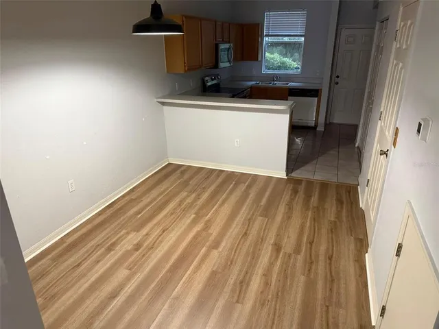 a kitchen with a sink and wooden floor