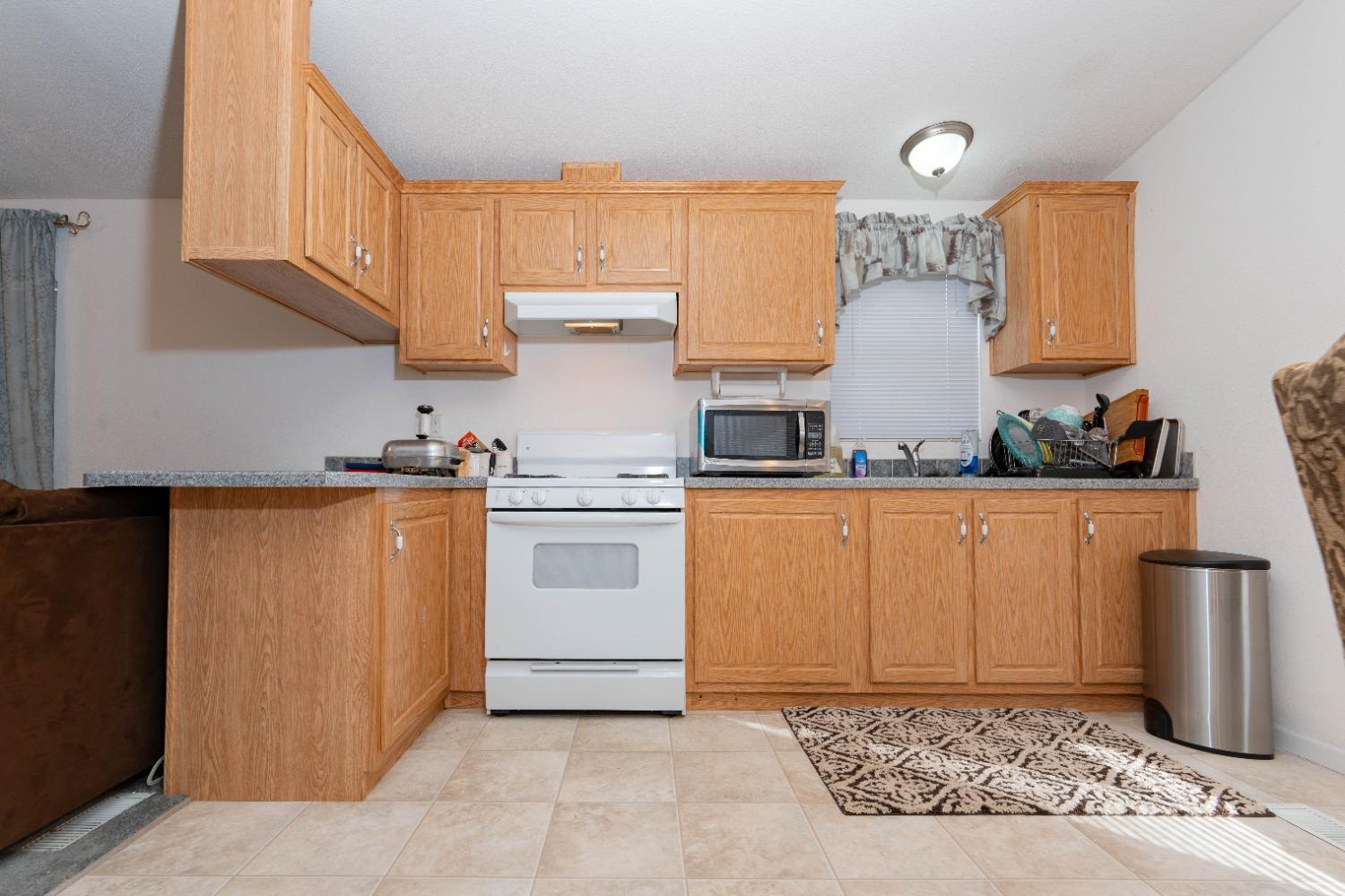 40778 Iris Road Squaw Valley, CA 93675 - Photo 14 of 44 a kitchen with white cabinets and white appliances