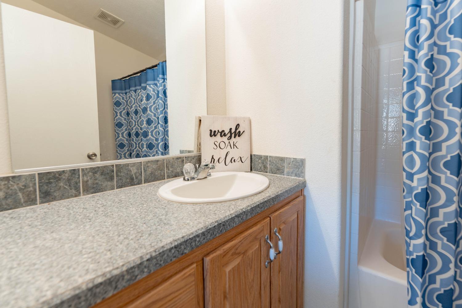 40778 Iris Road Squaw Valley, CA 93675 - Photo 21 of 44 a bathroom with a granite countertop sink and a mirror
