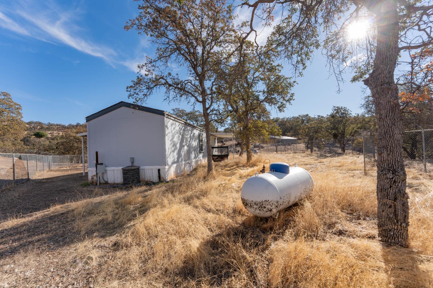 40778 Iris Road Squaw Valley, CA 93675 - Photo 3 of 44 a backyard of a house with table and chairs under an umbrella