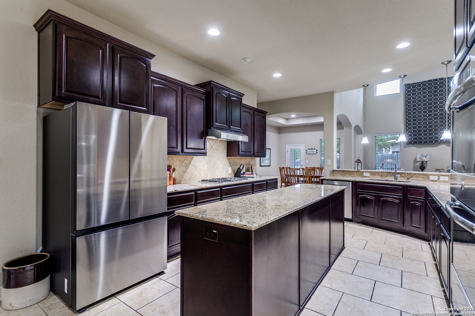 701 Morningside Drive Terrell Hills, TX 78209 - Photo 17 of 47 a kitchen with kitchen island granite countertop stainless steel appliances and a refrigerator