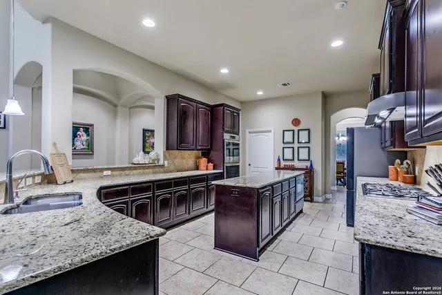 a kitchen with stainless steel appliances granite countertop a sink stove and refrigerator