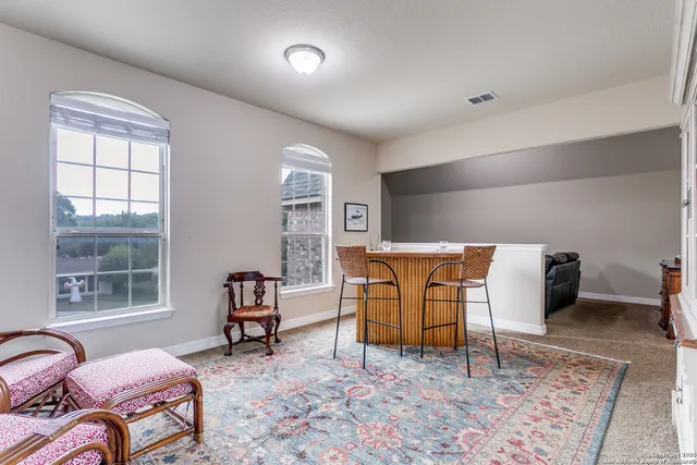 a living room with furniture a rug and a window