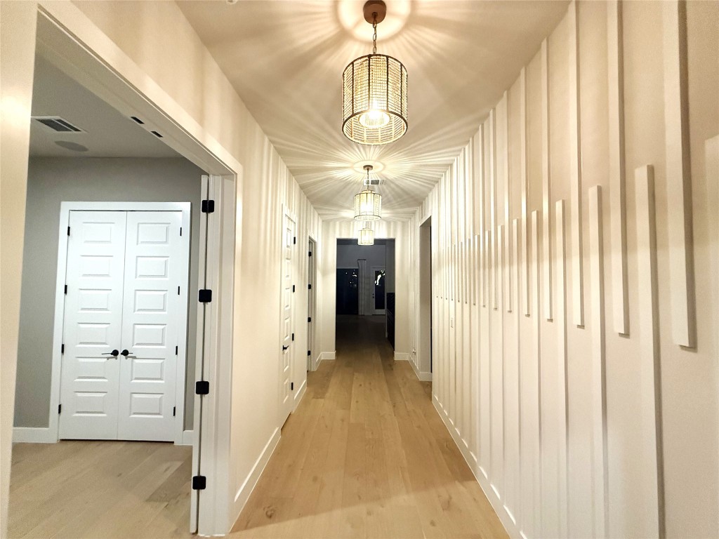 2002 Clearlight Lane Georgetown, TX 78633 - Photo 3 of 30 Hallway with light wood finished floors and a chandelier