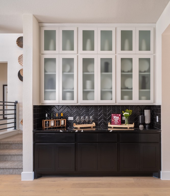 2002 Clearlight Lane Georgetown, TX 78633 - Photo 7 of 30 Bar area with tasteful backsplash, light wood-type flooring, and stairway