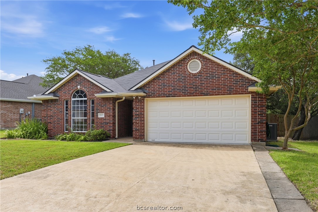 1707 Beaver Pond Court Bryan, TX 77807 - Photo 2 of 33 Brick exterior residence featuring a two-car garage, an arched window, and a gabled roofline