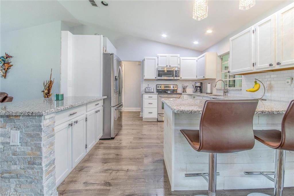 910 Liberty Lane Auburndale, FL 33823 - Photo 12 of 48 a kitchen with stainless steel appliances granite countertop a refrigerator and a stove top oven