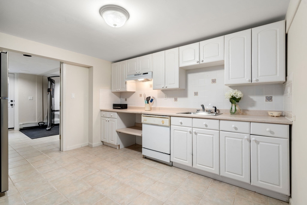 335 Conant Road Weston, MA 02493 - Photo 21 of 31 a kitchen with granite countertop white cabinets and white appliances