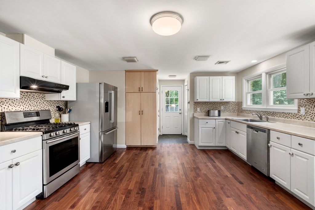 335 Conant Road Weston, MA 02493 - Photo 7 of 31 a kitchen with stainless steel appliances a stove a sink dishwasher a refrigerator and a wooden floor