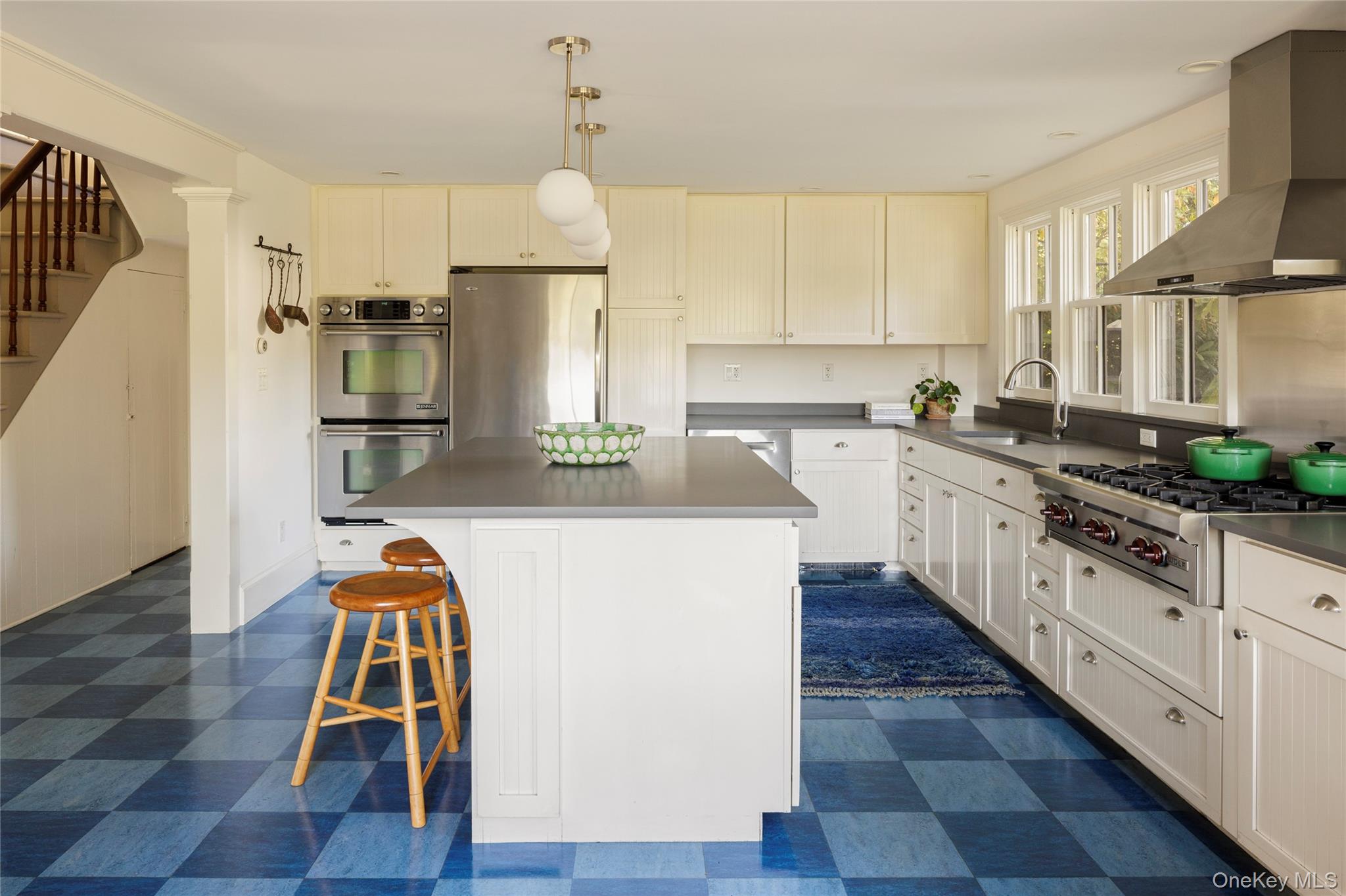 108 Wey Road Rhinebeck, NY 12572 - Photo 9 of 24 a kitchen with stainless steel appliances a refrigerator a stove a sink dishwasher and white cabinets with wooden floor