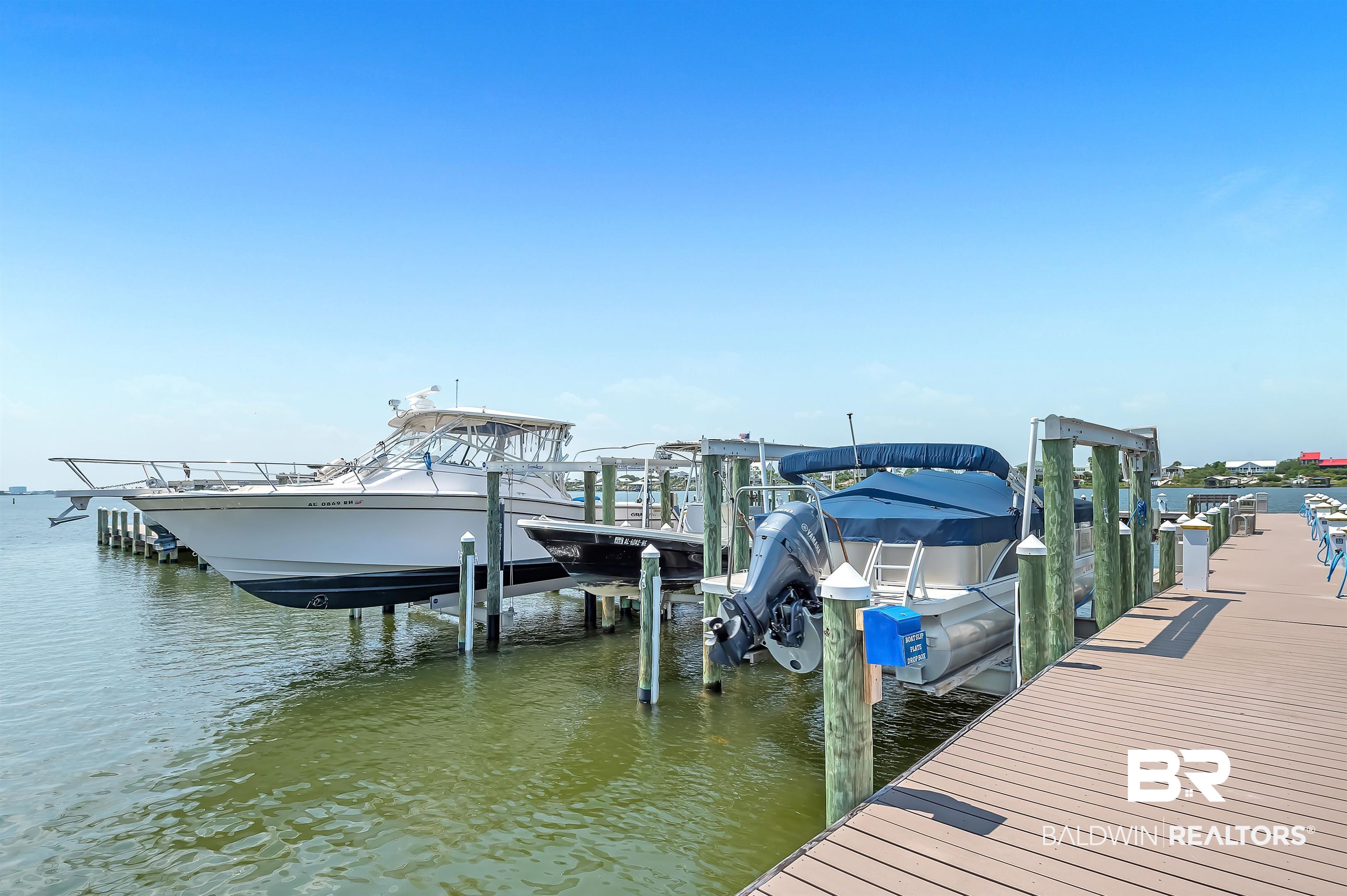 16287 Perdido Key Drive, Unit 105 Pensacola, FL 32507 - Photo 51 of 66 Composite decking pier featuring multiple boat slips with lifts
