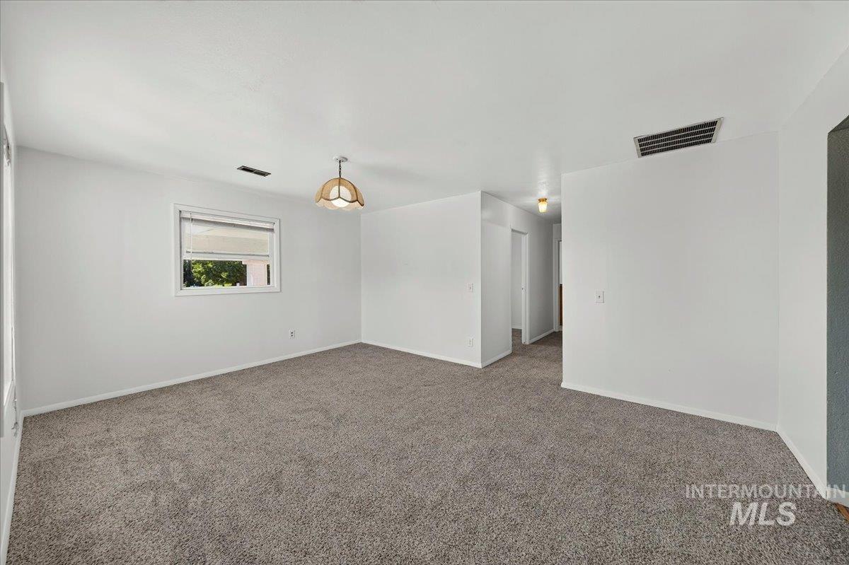 2160 South Five Mile Road Boise, ID 83709 - Photo 26 of 41 Open room featuring neutral-toned carpeting, a single window, and a ceiling-mounted light fixture