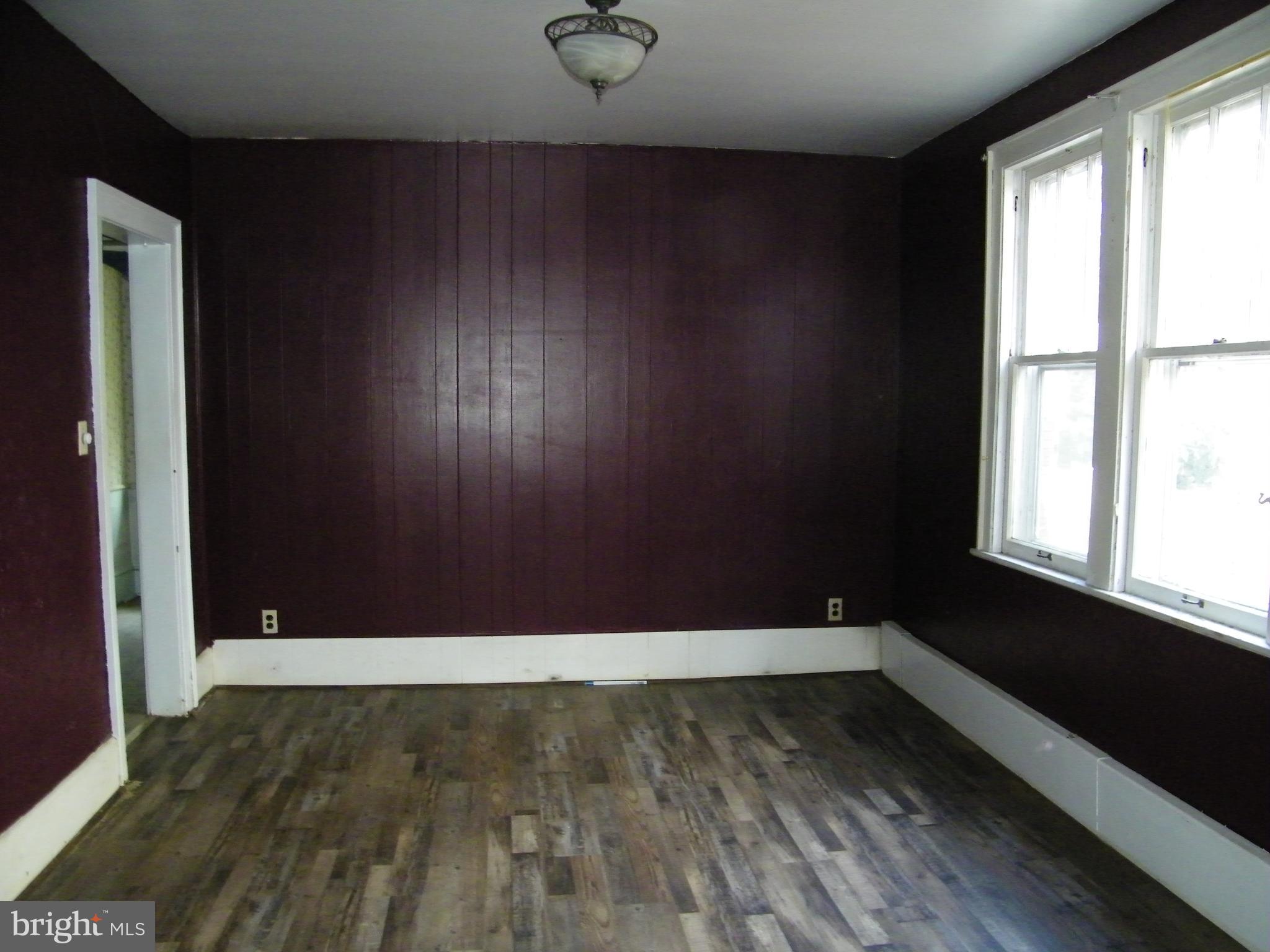 617 Frederick Street Cumberland, MD 21502 - Photo 7 of 16 an empty room with wooden floor and windows