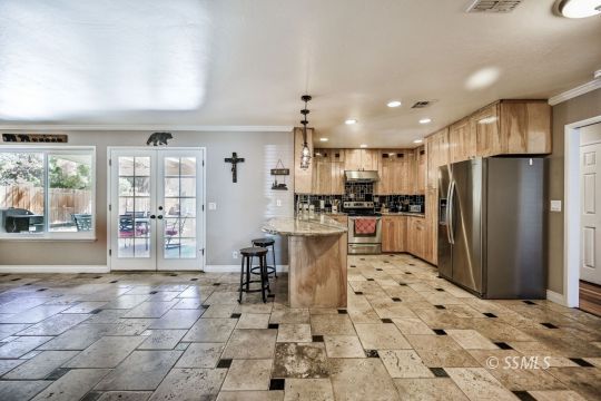725 West Howell Avenue Ridgecrest, CA 93555 - Photo 11 of 35 a kitchen with stainless steel appliances kitchen island granite countertop a refrigerator and a sink