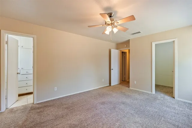 an empty room with closet and fan