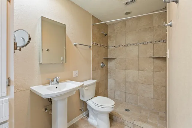 a bathroom with a sink toilet and shower