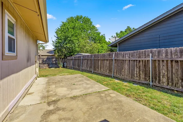 a view of backyard with small cabin and wooden fencing