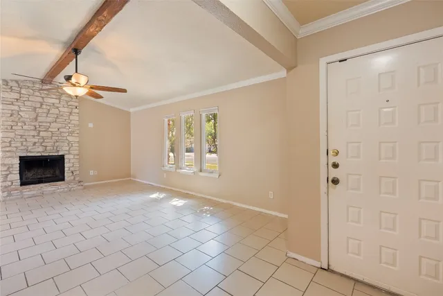 an empty room with windows and fireplace