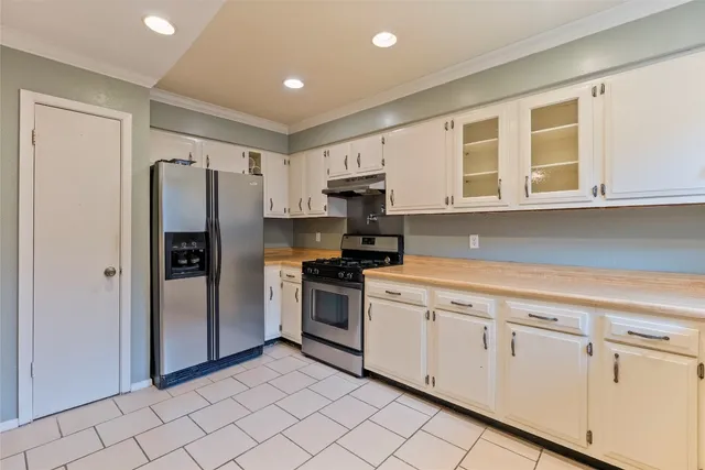 a kitchen with stainless steel appliances granite countertop a refrigerator and a stove top oven