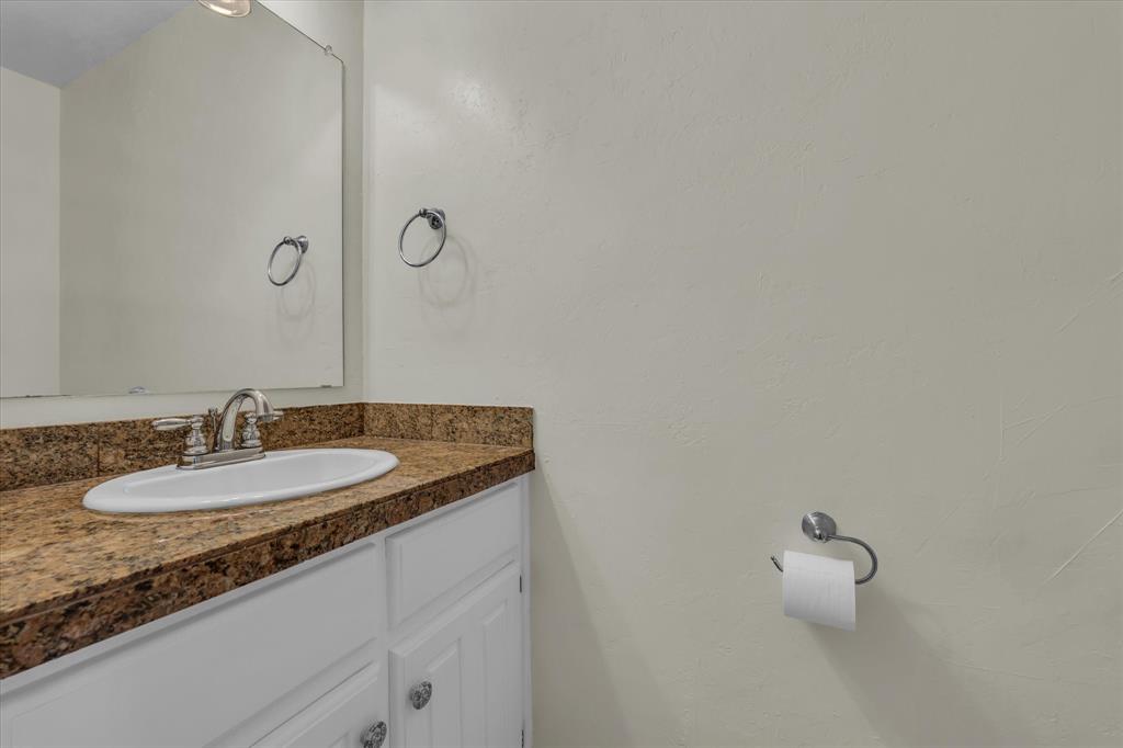 1365 South 11th Street Waco, TX 76706 - Photo 9 of 21 a bathroom with a granite countertop sink and a mirror