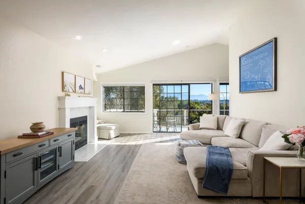 a living room with furniture a fireplace and a floor to ceiling window