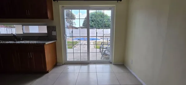 a view of an empty room with a kitchen