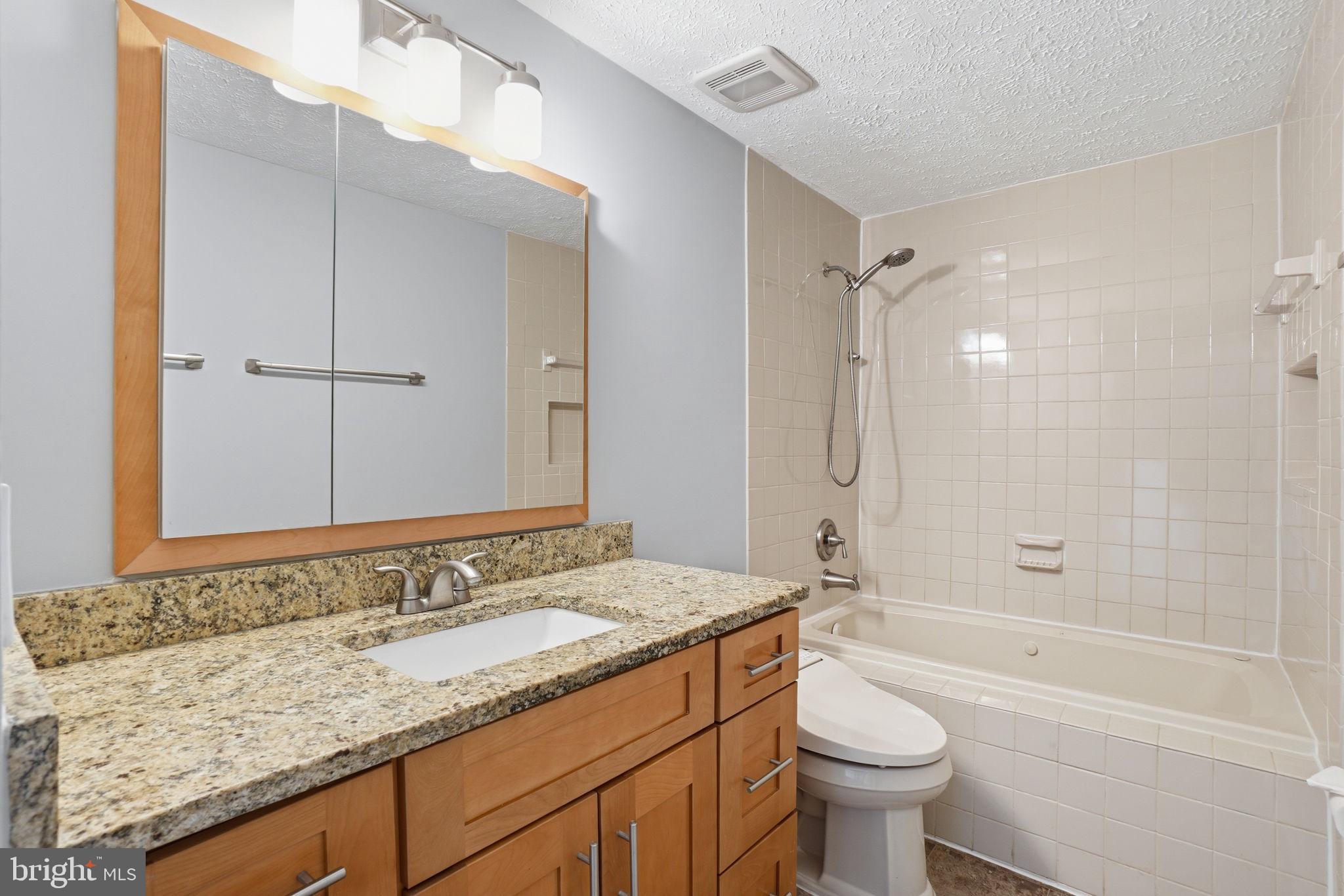 7470 Wounded Knee Road Lorton, VA 22079 - Photo 16 of 24 a bathroom with a granite countertop sink a toilet and shower