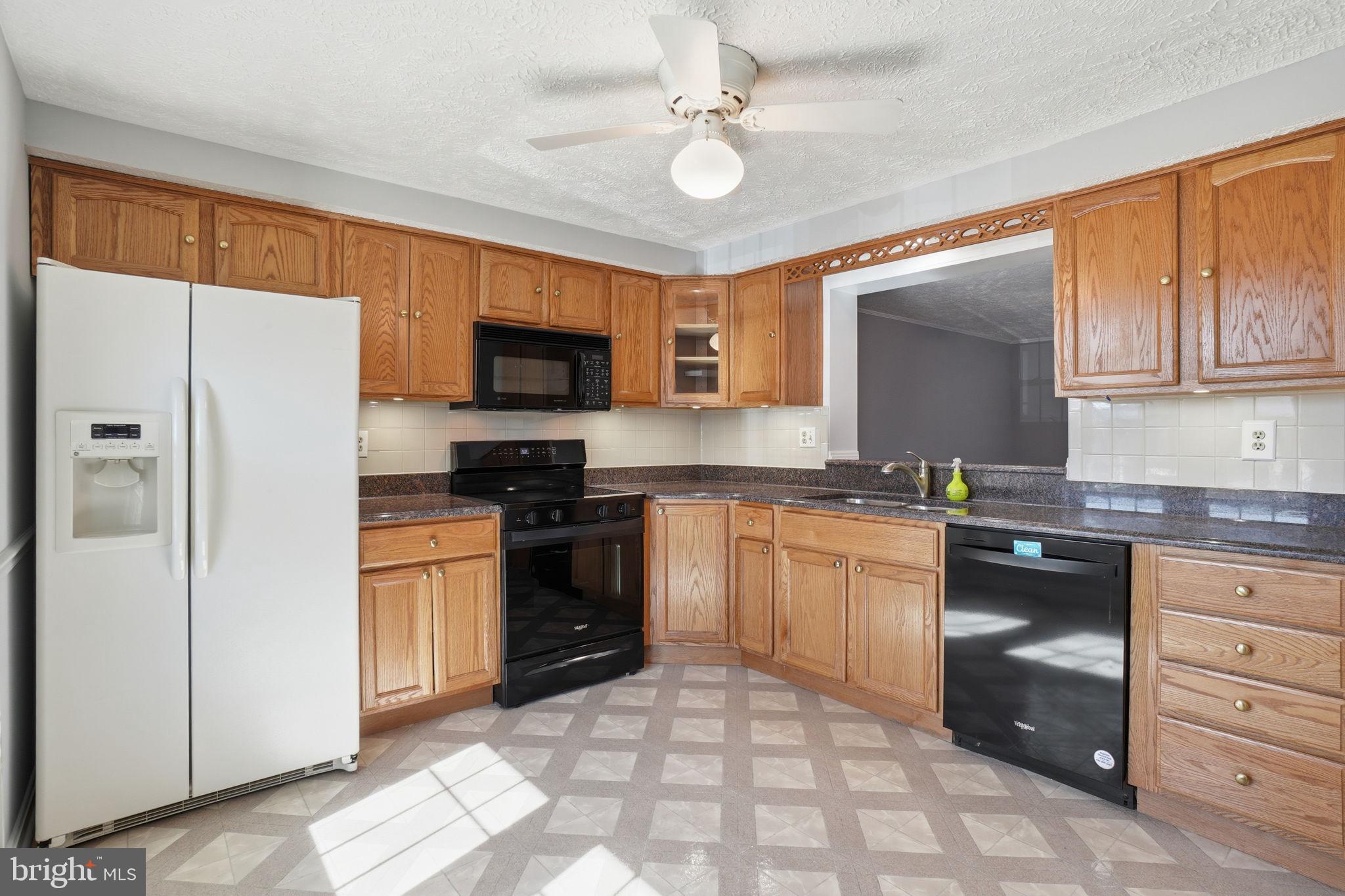7470 Wounded Knee Road Lorton, VA 22079 - Photo 4 of 24 a kitchen with granite countertop a refrigerator stove top oven a sink and dishwasher