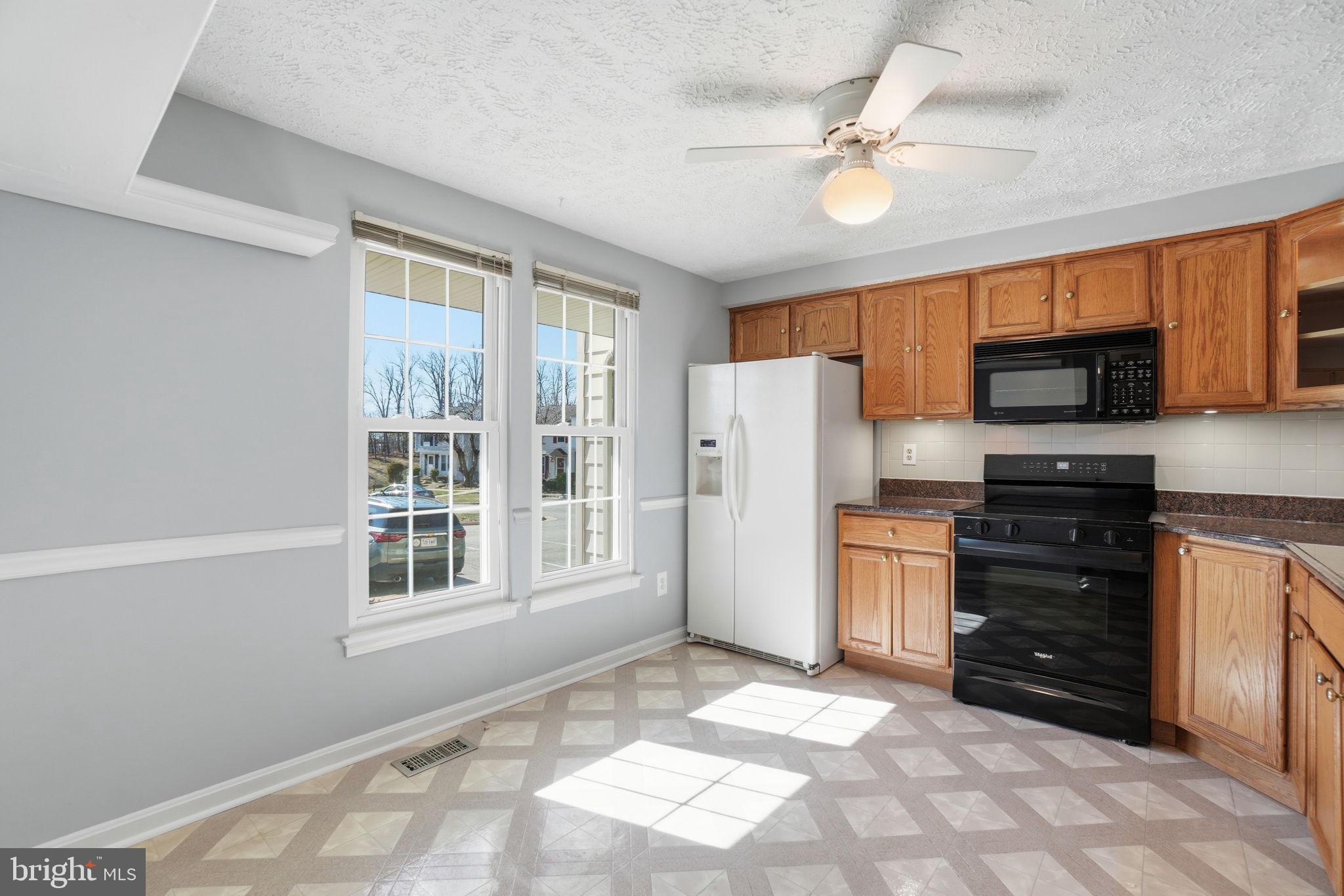 7470 Wounded Knee Road Lorton, VA 22079 - Photo 5 of 24 a kitchen with granite countertop a refrigerator and a stove top oven