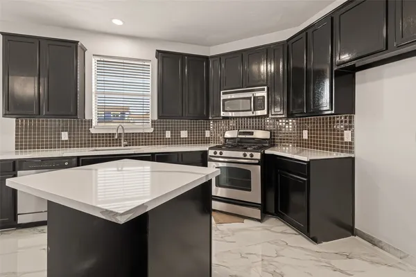 a kitchen with a sink stove and microwave
