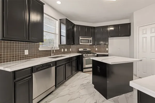 a kitchen with a sink stove and cabinets
