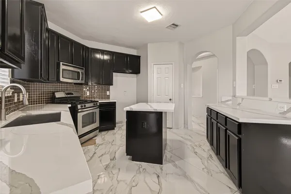 a kitchen with stainless steel appliances a stove sink microwave and cabinets