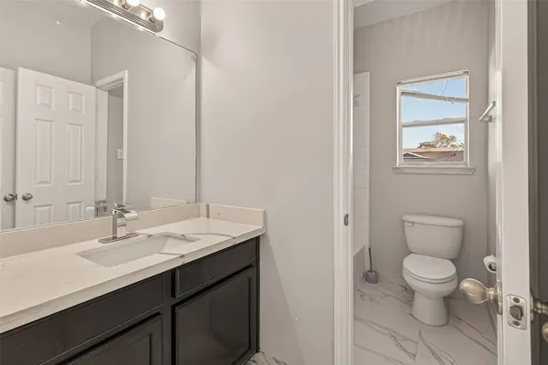 a bathroom with a sink toilet and vanity