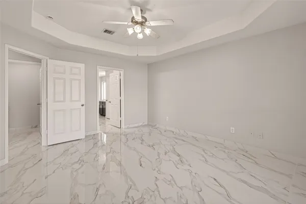 wooden floor in an empty room with a ceiling fan