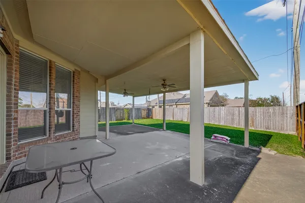 a view of a backyard with table and chairs under an umbrella