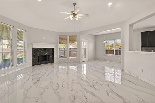 a view of an empty room with a fireplace and a window