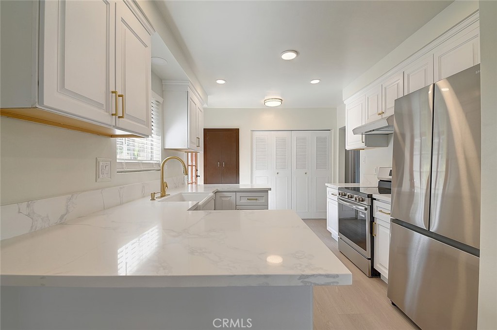 9118 Maple Street Bellflower, CA 90706 - Photo 16 of 74 a kitchen with stainless steel appliances a refrigerator and a stove top oven