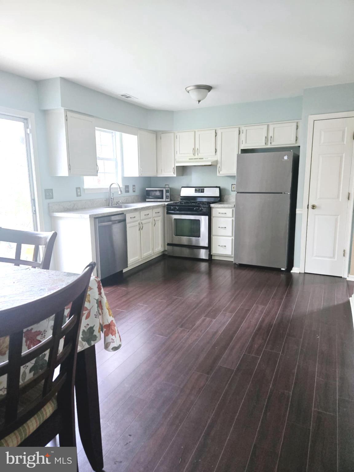 3505 Tall Pines Pine Hill, NJ 08021 - Photo 4 of 10 a kitchen with a refrigerator a sink dishwasher a stove and white cabinets with wooden floor