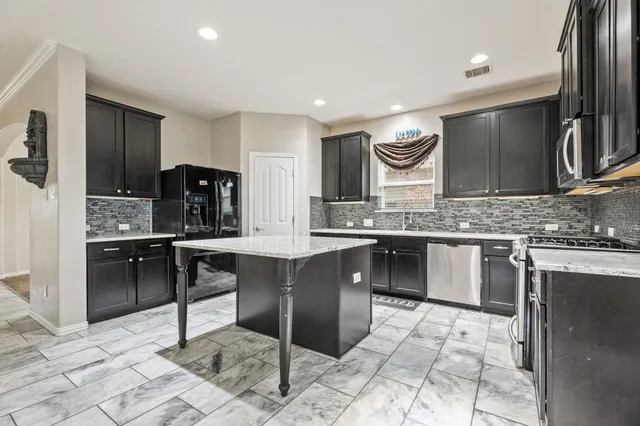 a kitchen with stainless steel appliances kitchen island granite countertop a sink and cabinets